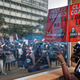 An environmental protester points his finger at the reflective window of the Ministry of Interior, as he demonstrates against recent government plans to mine coal and open a coal-fired power plant, in downtown Nairobi, Kenya Tuesday, June 5, 2018. Kenyan activists protested plans for the joint venture between the Kenyan and Chinese governments in Lamu County, saying it will have devastating effect on the environment and health of local populations.